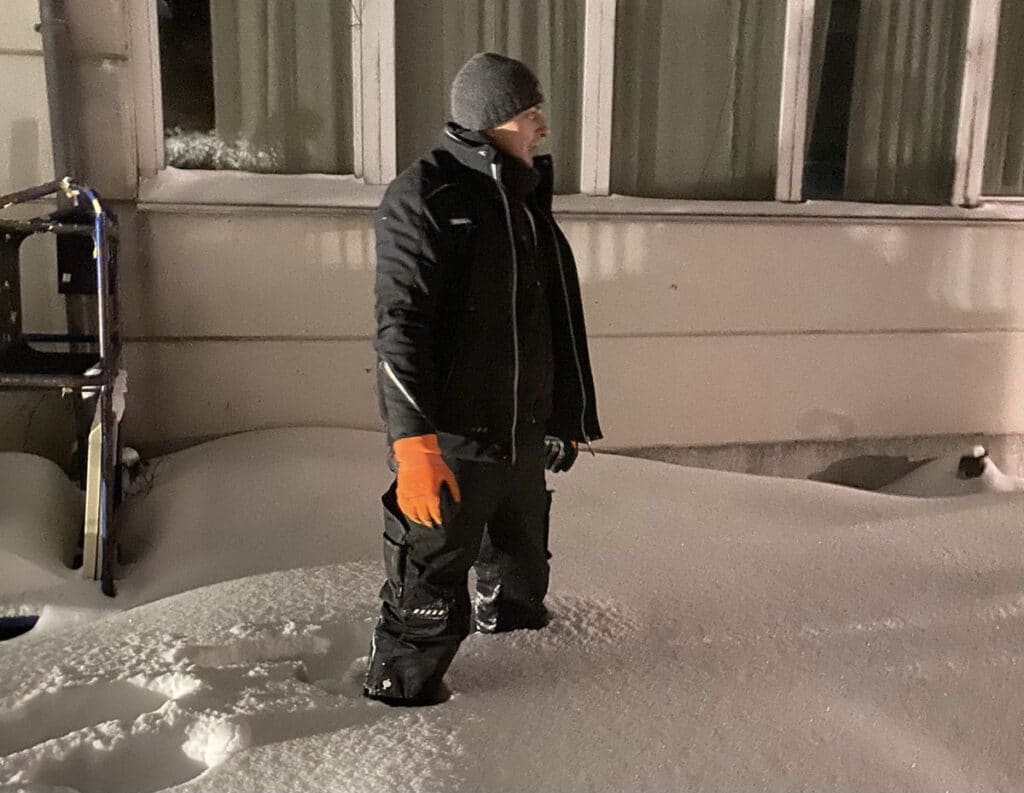 Mitarbeiter von Mobile Wärme 24 steht bis zu den Knien im Schnee