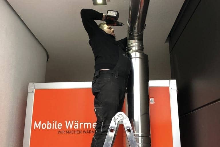 Anlagenmechaniker von Mobile Wärme 24 arbeitet an einer Abgasführung
