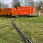 Defekte Heizung nach Hochwasser: Heizungsschläuche vom mobiler Heizzentrale in den Keller