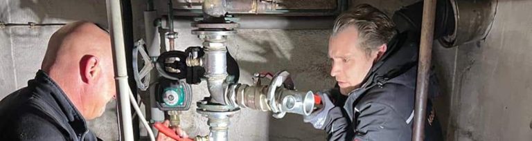 Installateure der Mobile Wärme 24 GmbH bauen die Anschlüsse einer bauseitigen Heizanlage um