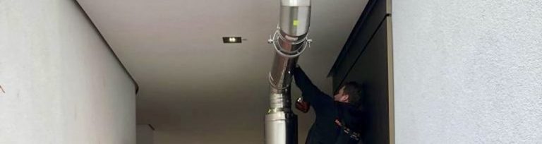 Anlagenmechaniker von Mobile Wärme 24 arbeitet an Abgasführung
